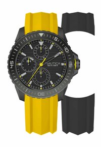 Reloj Nautica con caja negra, esfera negra, acentos amarillos y correa de silicona amarilla. Incluye una correa de silicona negra adicional.
