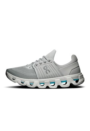 Chaussure de course gris clair avec tige en mesh, semelle blanche avec segments de coussin évidés et logo sur le côté.