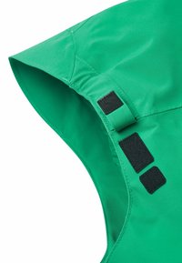 Grüne wasserdichte Stoffkapuze mit schwarzen Velcro-Akzenten und geschmeidiger Textur, versehen mit einem strukturierten, ordentlich genähten Design.