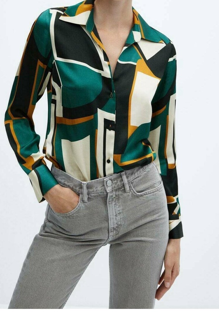 Chemise à boutons verte, crème et orange avec un motif géométrique ; manches longues ; tissu léger ; associée à un pantalon en denim gris.