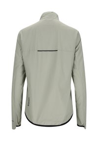 Lys grå jakke med høj krave, glat stoftekstur, rundet nederkant og en vandret sort stribe nær den øvre ryg.