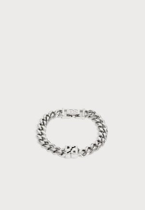 Bracelet chaîne en argent avec des maillons épais et un fermoir avec les lettres "DS" sur un fond clair uni.
