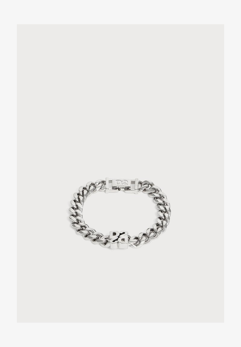 Bracelet chaîne en argent avec des maillons épais et un fermoir avec les lettres "DS" sur un fond clair uni.