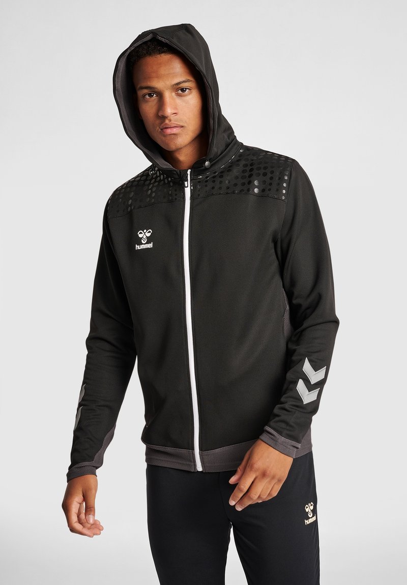 Felpa nera con zip, design testurizzato sulle spalle, zip bianca e logo. Presenta un cappuccio e dettagli grigi a contrasto sulle maniche.