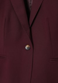 Bordeaux blazer met een enkele knop, notch revers en twee zijzakken. Gemaakt van een gladde stof met subtiele stikdetails.