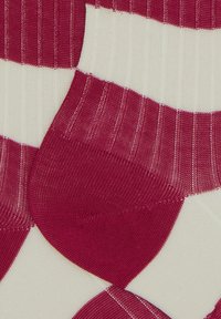 Calzini a righe rosse e bianche con texture a costine, dotati di punta e tallone rinforzati per una maggiore durabilità. Composizione in tessuto morbido e elastico.