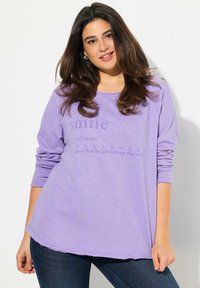 Camicia a maniche lunghe lavanda con scollatura rotonda. Il testo sul davanti recita "sorridi" e la sua definizione. Tessuto morbido e leggero con una vestibilità comoda.