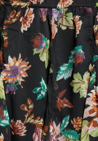 Tela negra con pliegues, que presenta un colorido patrón floral de hojas y flores en naranja, púrpura, verde y marrón.