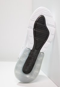 Weißer Sportschuh mit strukturiertem Obermaterial, klarer Luftsohle für Dämpfung und schwarzem Gummiaußensohle. Verfügt über sichtbare Markenkennzeichnung auf der Sohle.