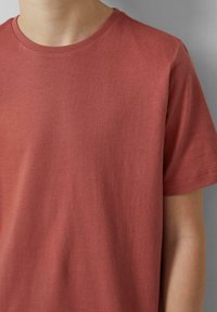 Rode katoenen T-shirt met een ronde hals, korte mouwen en een gladde textuur. Bevat topstiksels langs de mouwranden voor extra detail.