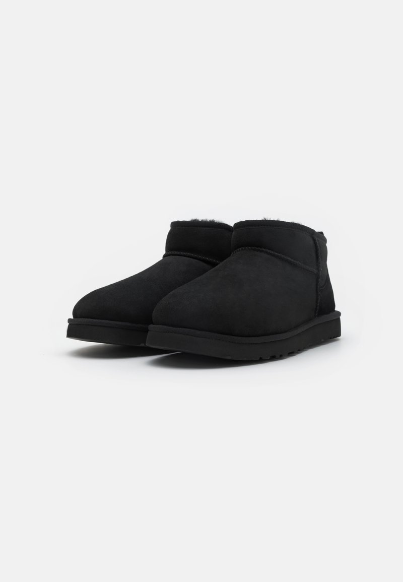 Bottines en suède noir à bout arrondi et doublure douce, présentant une semelle en caoutchouc à profil bas et un design minimaliste.