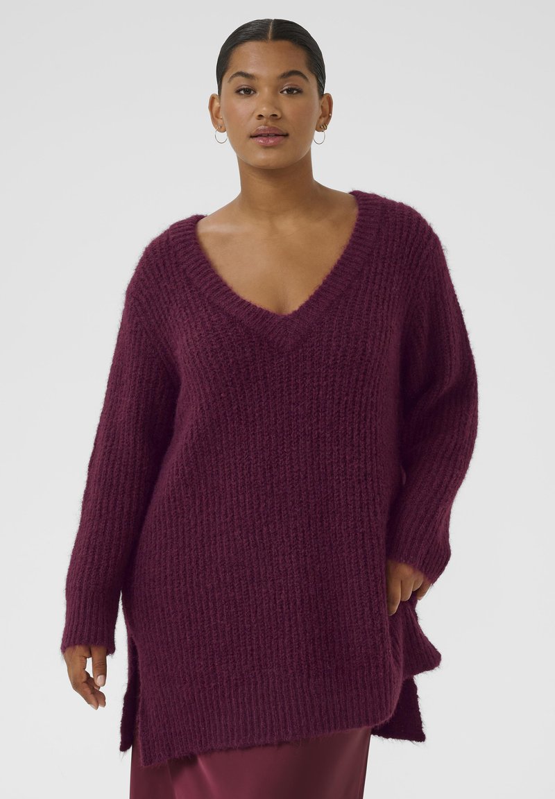 Maglione oversized a V in borgogna, texture a coste, maniche lunghe, tagli laterali, realizzato in materiale morbido e lavorato a maglia.