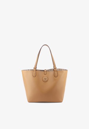 Sac fourre-tout en cuir tan avec double poignée, emblème logo circulaire sur le devant et doublure intérieure en tissu à motifs.