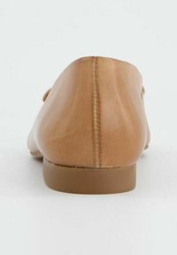 Tan leren ballerina's met een gladde textuur, ronde achterkant, minimalistisch ontwerp en een lage, matte bruine zool.