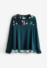 Langärmliges Oberteil in dunklem Petrol mit floralem Muster an der Passe. Weicher Stoff, runder Halsausschnitt, mehrlagiger Saum mit zartem Blumenmuster am unteren Rand.