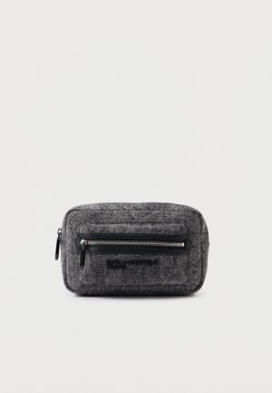 Kompaktowa prostokątna torba z szarego materiału z przednią kieszenią na zamek błyskawiczny i czarnymi uchwytami zamka, oznaczona napisem "Karl Lagerfeld Jeans" z przodu.