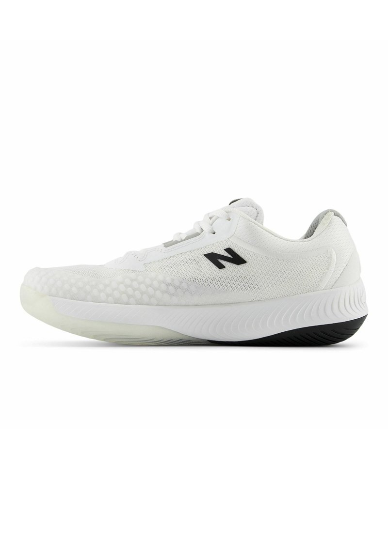 Zapatillas deportivas blancas con parte superior de malla texturizada, logo negro y suela de goma flexible que presenta una ligera curva y un patrón de tracción pronunciado.