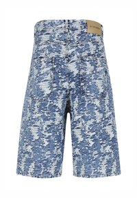 Shorts en denim délavé bleu et blanc avec poches arrière et une étiquette de marque beige sur la ceinture.