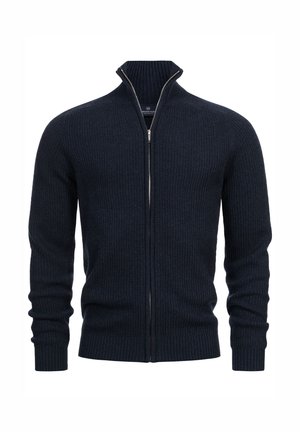 Mörkblå ribbad stickad zip-up tröja med hög krage, som har en silverdragkedja och åtsittande muddar. Mjuk textur med en figurnära design.