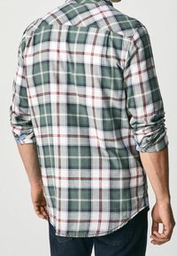 Rutigt skjorta i grönt, vitt och rött; knäppning med krage; uppvikta ärmar; lättviktsmaterial; rundad nederkant; avslappnad passform.