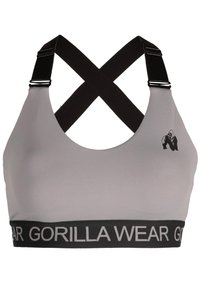 Sujetador deportivo gris con tirantes entrecruzados negros. Presenta un logo negro y una banda elástica de contraste con el texto "GORILLA WEAR". Textura suave.