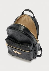 Μαύρο σακίδιο από ψεύτικο δέρμα με ανάγλυφο σχέδιο, διπλό φερμουάρ, μπροστινή τσέπη και εξαρτήματα σε χρυσή απόχρωση. Επενδυμένο με μπεζ ύφασμα.