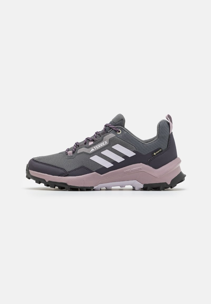 Graue und lila Wanderschuhe mit Obermaterial aus Mesh, verstärkter Zehenkappe und Gummisohle. Verfügt über drei weiße Streifen und strukturierte Schnürsenkel.