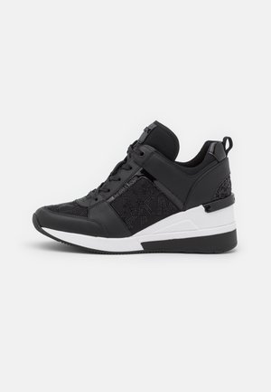 Schwarzer Keil-Sneaker mit Schnürsenkeln, einem Riemen vorne, strukturierten Stoffseiten und einer schwarz-weißen Sohle.