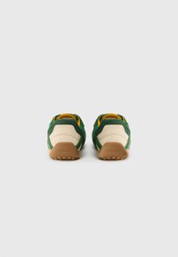 Πράσινα και μπεζ αθλητικά παπούτσια από δίχτυ με καουτσούκ σόλα. Διαθέτουν κίτρινες λεπτομέρειες και υφασμένη, αναπνέουσα σχεδίαση. Λογότυπο Geox στη φτέρνα.