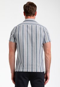 Košile s krátkým rukávem v modro-bílé vertikální pruhované váze s texturovaným vzorem a rovnym lemem. Klasický design límce.