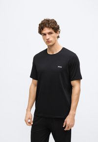 Μαύρο κοντομάνικο T-shirt με στρογγυλή λαιμόκοψη, κατασκευασμένο από απαλό ύφασμα. Φέρει μικρό λευκό λογότυπο "BOSS" στο στήθος. Απλός, εφαρμοστός σχεδιασμός.