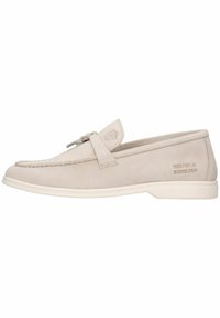 Mocassini in suede beige con finitura liscia, caratterizzati da un cappio decorativo e un marchio sottile sul lato, abbinati a una suola in gomma bianca.