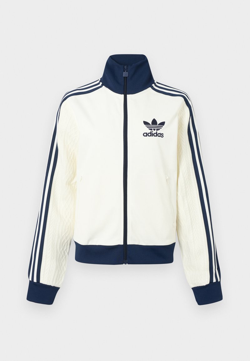 White Adidas jacket with navy accents, featuring a high collar, zip closure, and three-stripe design on sleeves. Textured side panels.