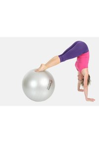 Gimnastičarka izvodi stojeći položaj na velikoj srebrnoj lopti za vježbanje. Figurina nosi ružičastu majicu i ljubičaste tajice, s golim nogama na lopti.