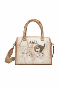 Tasche in Beige mit geflochtenen Griffen, die eine verspielte Illustration, leichte Texturakzente und dekorative Nähte auf einem sanften Hintergrund zeigt.