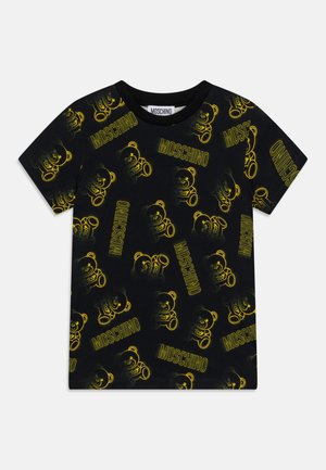 T-shirt noir à manches courtes avec motif répétitif d'ourson jaune et texte "MOSCHINO" sur toute la surface.