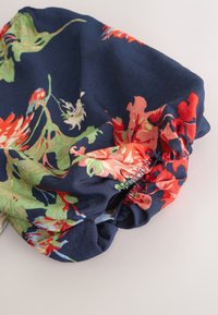Elastisk navyblå ærme med rynket manchet med flerfarvet blomsterprint i røde, grønne og orange nuancer.