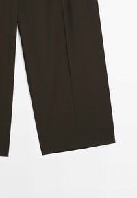 Pantalon marron foncé à jambes larges avec une texture de tissu lisse, présenté de la partie supérieure à la partie inférieure sur un fond blanc.