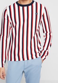 Gestreifter langärmeliger Pullover in Weiß, Rot und Marineblau, mit horizontalen Streifen, geripptem Material und Rundhalsausschnitt mit Logodetail.