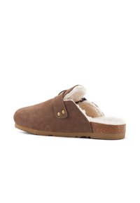 Hnedé semišové nazúvacie kliny s mäkkou bielou kožušinovou podšívkou, zaoblenou špičkou a gaštanovou gumovou podrážkou. Obsahujú postranný popruh so zlatým kovovým detailom.