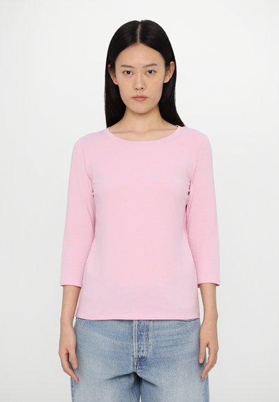 Top rose à manches longues avec un col rond, fabriqué à partir d'un tissu léger. Dispose de manches ajustées et d'une texture lisse et douce.