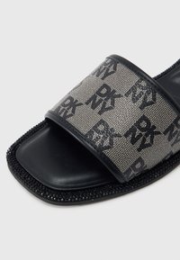 Μαύρο και γκρι σανδάλι slide με λουράκι από υφαντό ύφασμα με επαναλαμβανόμενο μοτίβο λογοτύπου, μαύρη λεία σόλα και λαμπερή διακοσμητική τρέσα με χάντρες.