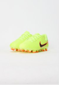 Lys gule fodboldstøvler med tekstureret overflade, sort Nike-logo, orange detaljer og multifarvede studs til greb.