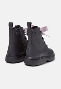 Stivaletti neri in pelle con finitura testurizzata, dotati di lacci viola e zip laterale. Progettati con una suola in gomma resistente per una migliore aderenza.
