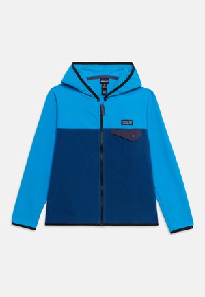 Veste à capuche zippée en bleu clair et bleu foncé avec une petite poche poitrine boutonnée et le logo Patagonia sur le côté gauche.