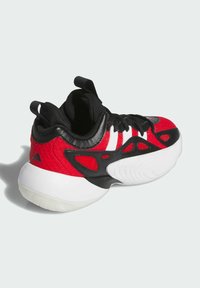 Scarpa sportiva rossa e nera con soprattetto testurizzato, tre strisce bianche, accenti neri e una suola in gomma bianca con motivi di trazione.