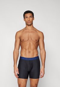 Boxer-briefs noirs avec une ceinture de marque bleue, offrant un ajustement serré et une texture lisse, conçus pour le confort et le soutien.