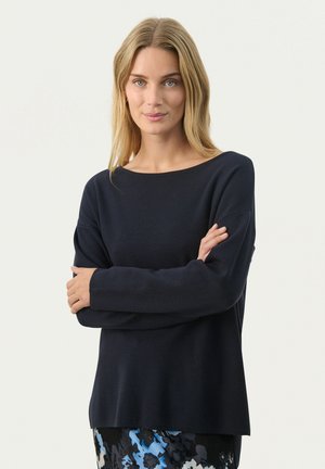 Pull en maille marine avec un encolure large, des manches longues et une coupe décontractée. Texture lisse avec des détails côtelés subtils au niveau des poignets.