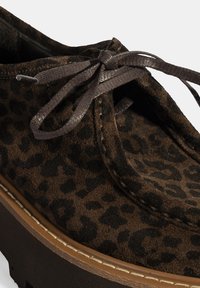 Schuhe aus braunem Leopardenmuster-Suede mit runder Zehenpartie, Schnürung und dicker brauner Plattformsohle. Texturierte Oberfläche und kontrastierende Schnürsenkel.