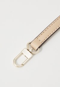 Cintura in pelle beige con bordi scuri, dotata di accessori in argento e cuciture a vista. Texture piatta e liscia con un gancio arrotondato.
